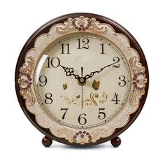 an ornate wooden clock with roman numerals on the face and numbers in gold