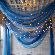 a room filled with lots of blue drapes and lights