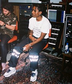 two young men sitting in front of sound equipment