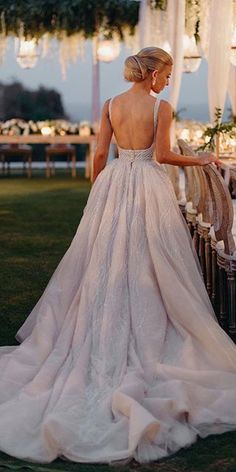 the back of a woman's dress as she stands in front of an outdoor setting