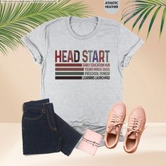 a t - shirt with the words head start on it next to jeans and sneakers