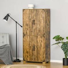 a tall wooden cabinet sitting next to a lamp on top of a hard wood floor