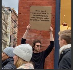 a man holding up a sign that says never have it ever at home all day drinking vodka then went and picked my child up from school