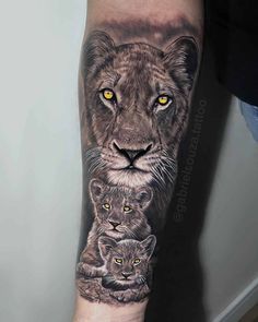 a man's arm with a lion and two cubs on it, in black and grey