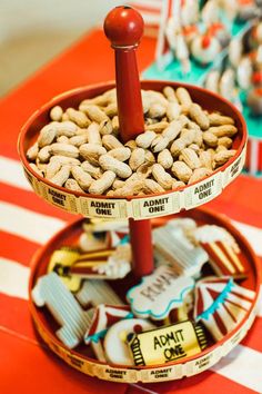 two tiered trays filled with nuts on top of a red and white table cloth