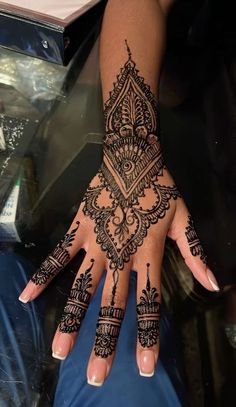 a woman's hand with henna tattoos on it