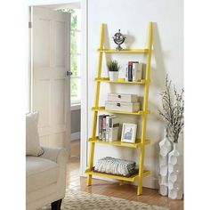 a yellow leaning shelf with books on it in a living room next to a white door