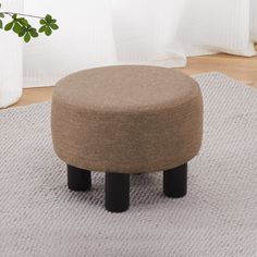 a round ottoman sitting on top of a rug