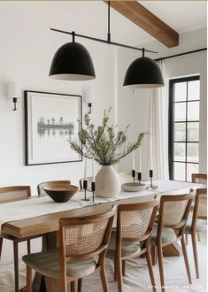 a dining room table with chairs and a vase on it