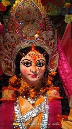 a close up of a statue of a person wearing an elaborate headdress and makeup