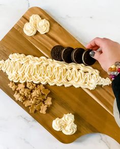 someone is decorating some desserts on a wooden board