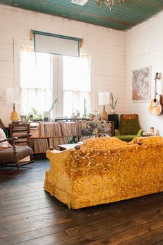 a living room filled with furniture and lots of books on top of a hard wood floor