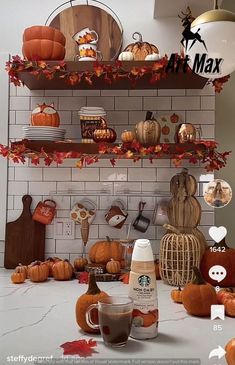 there are many pumpkins and other decorations on this kitchen counter top, along with coffee