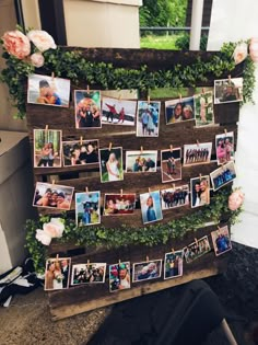 a wooden sign with pictures hanging from it's sides and flowers on the side