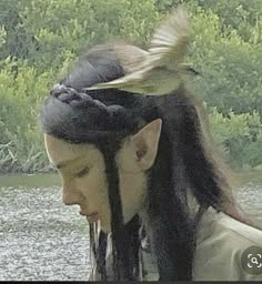 a man with long hair and a bird on his head