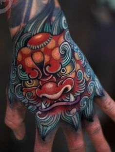 a person's hand with a colorful tattoo on it