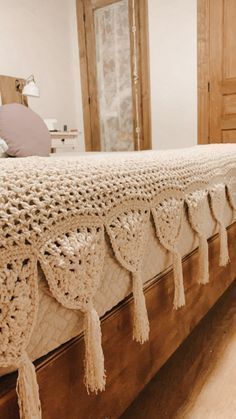 a crocheted bedspread with tassels on the bottom and sides