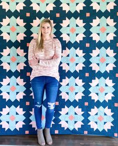 a woman standing in front of a quilt