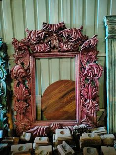 an ornate wooden mirror sitting on top of a table