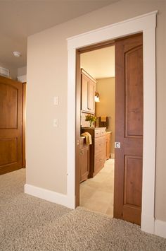 an open door leading into a bedroom with carpeted flooring and wooden cabinets in the background