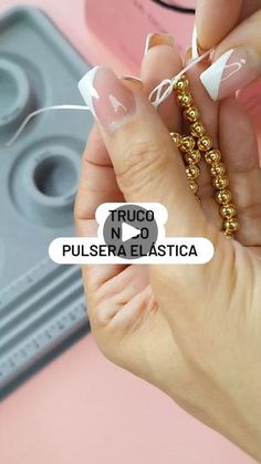 a woman is holding some beads in her hand and the words truco n no pulsera elastica on it