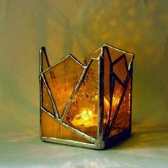 a glass candle holder sitting on top of a table