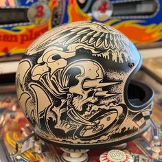 a helmet sitting on top of a pinball machine