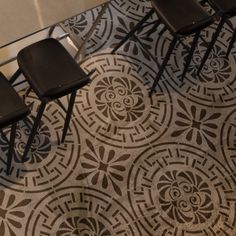 three black chairs sitting on top of a tiled floor