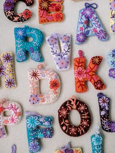 the letters are made out of fabric and decorated with flowers