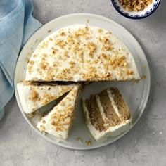 a cake with white frosting and crumbled toppings sits on a plate