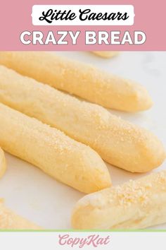 some bread sticks are sitting on a white surface with the words, little caesars crazy bread