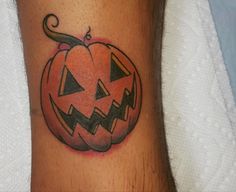 a tattoo on the leg of a person with a jack - o'- lantern