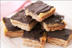 chocolate and peanut butter bars stacked on top of each other in a plate with one bite taken out