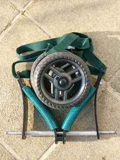 a steering wheel on top of a blue seat belt with a green strap around it