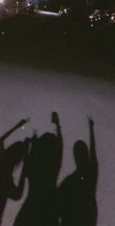 the shadow of two people holding their arms up