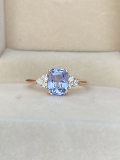 a blue and white diamond ring in a box