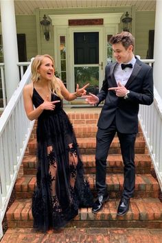 a man in a tuxedo standing next to a woman on stairs