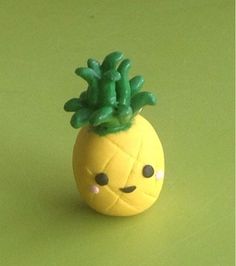 a small toy pineapple sitting on top of a green surface