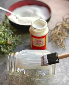 a glass jar filled with white stuff next to a brush