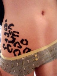 a woman's stomach with an animal print tattoo on her lower back and side