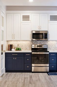 a kitchen with white cabinets and blue counter tops, stainless steel appliances and an oven