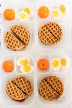 several breakfast foods in plastic containers with eggs and oranges on the side, including waffles