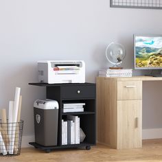 a computer desk with a printer and other office supplies on it next to a wall