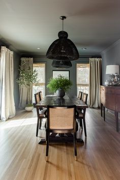 a dining room table with chairs and a potted plant on top of the table