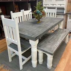 a kitchen table with two benches and a vase on it in front of the counter