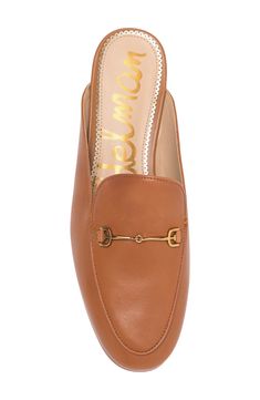 A glittery scalloped insole trim adds dainty style to this sleek mule that has brassy goldtone hardware and a subtle heel. Synthetic or leather upper and lining/rubber sole Imported Classic Low Heel Mules With Branded Insole, Classic Mules With Branded Insole And Low Heel, Chic Mules With Leather Footbed And Almond Toe, Chic Mules With Almond Toe And Leather Footbed, Chic Almond Toe Leather Mules, Classic Gold Mules For Spring, Gold Low Heel Mules For Formal Occasions, Elegant Leather Footbed Mules For Fall, Gold Mules For Formal Occasions