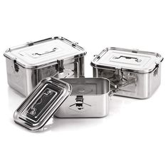 three stainless steel lunch boxes with lids on each side and one in the middle filled with food