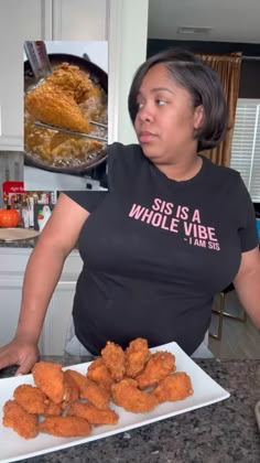 a woman standing in front of a plate of fried food