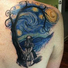 the back of a woman's shoulder with a starr sky and tree tattoo on it