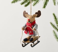 a christmas ornament hanging from a tree with a reindeer on it's back